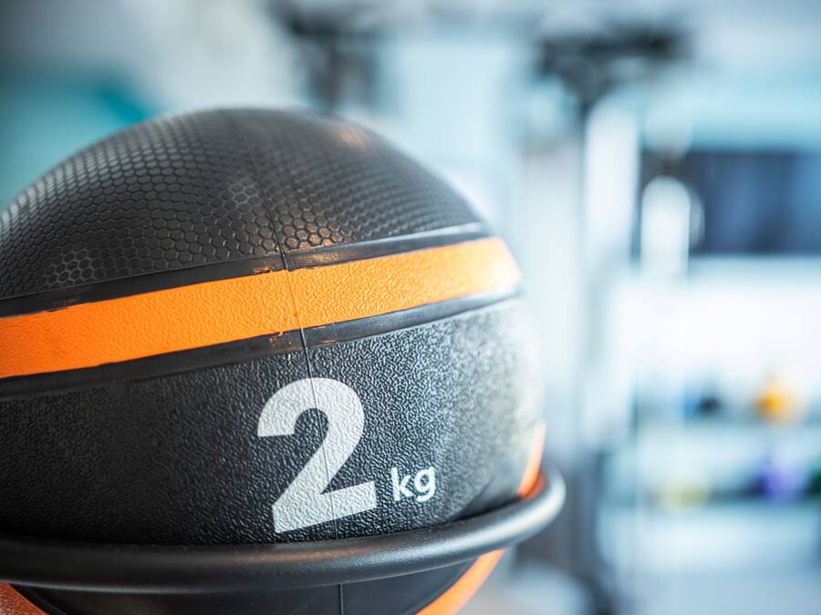 Primer plano de un balón de baloncesto negro y naranja con el número 2 y la etiqueta '2 kg'.
