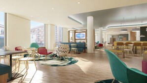A modern hotel lobby with a mix of seating areas, a central television, and large windows offering city views.