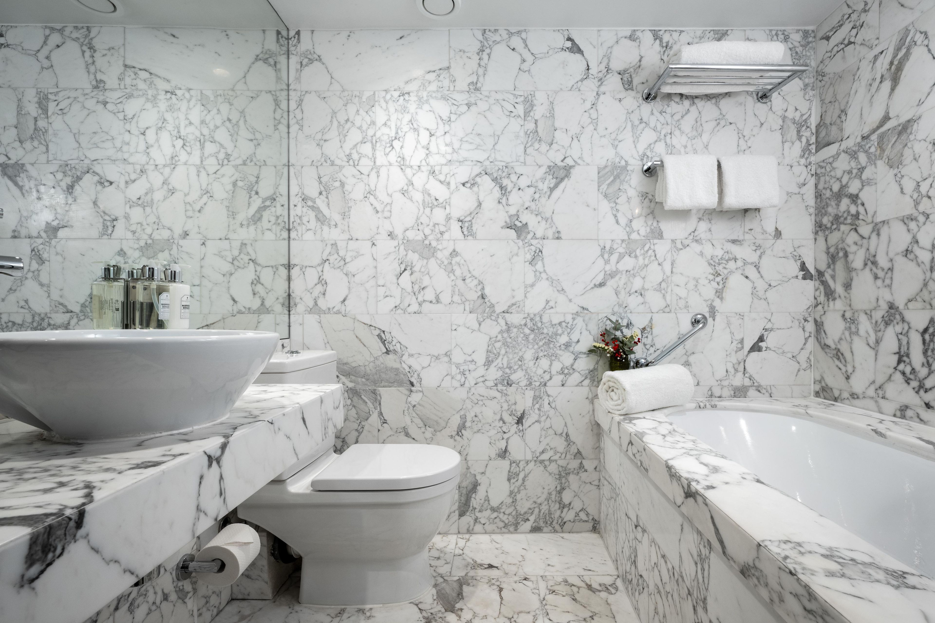 A bathroom with a marble sink, toilet, and bathtub.