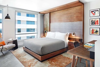 A modern hotel with a prominent vertical orange accent, a glass facade, and a rooftop terrace. at Canopy by Hilton Tempe Downtown