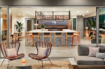A modern interior with a wooden ceiling, large windows, and a yellow sofa. at Canopy by Hilton Tempe Downtown