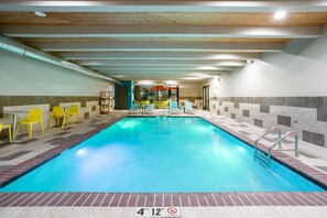 An indoor swimming pool with a 4'12" depth, yellow chairs, and a tiled floor. - Home2 Suites by Hilton Roswell, NM (Roswell)