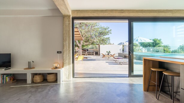 Een moderne woonkamer met een grote schuifdeur die uitkomt op een terras.
