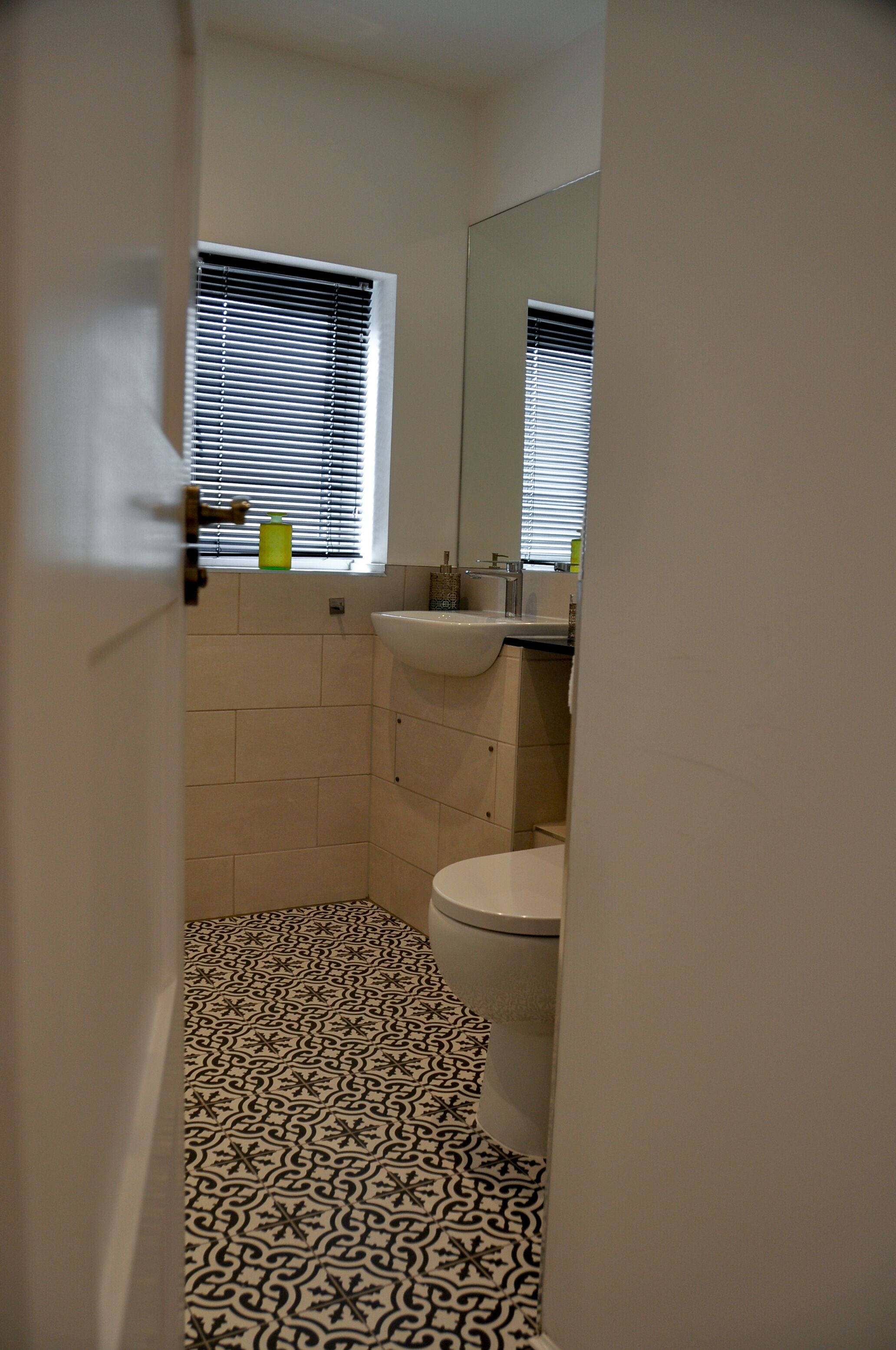 Ein Badezimmer mit Toilette, Waschbecken und einem Fenster mit Jalousien.