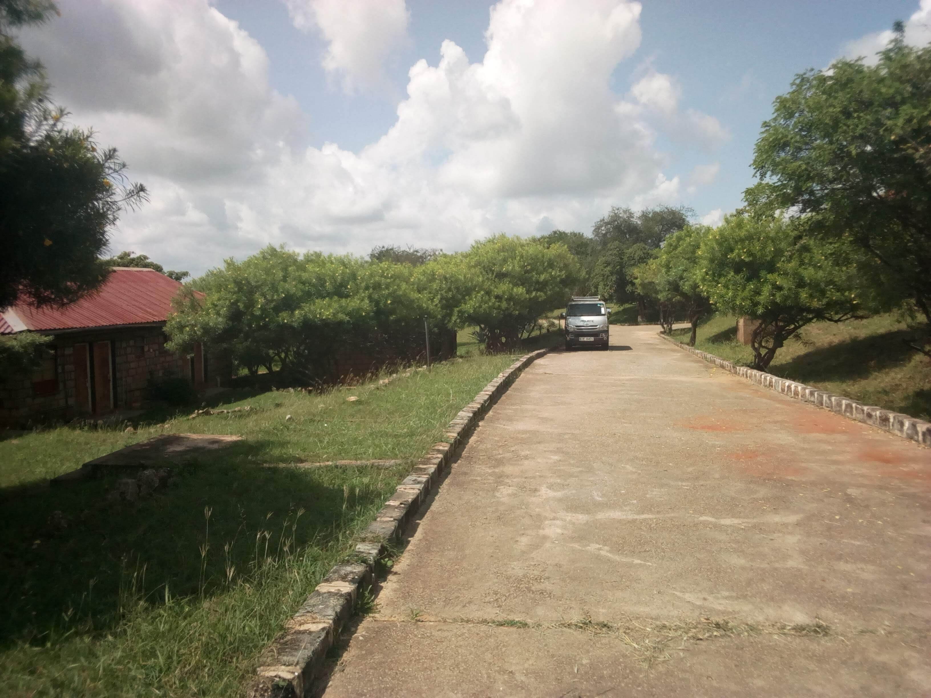 A rural road with a white vehicle parked on the side.