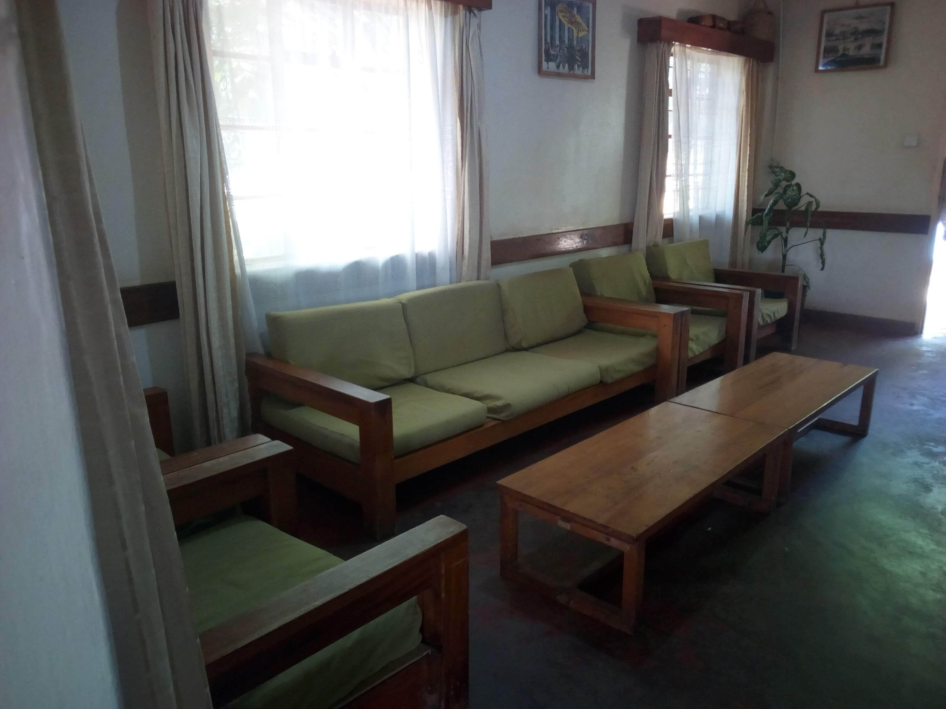 Un salon comprenant un canapé, deux fauteuils et une table basse en bois.