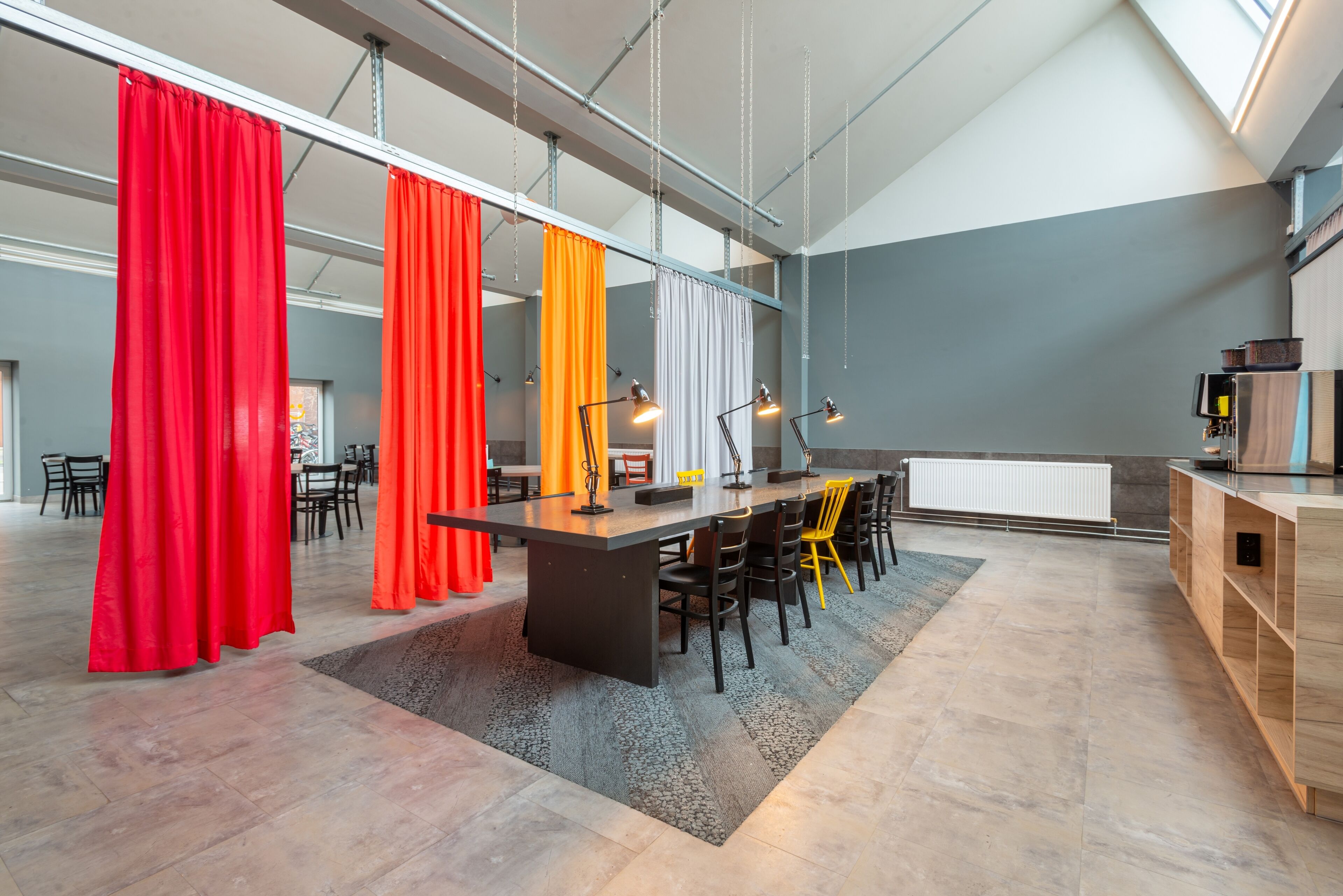Une cuisine moderne dotée d’un îlot central, de tabourets de bar et de luminaires suspendus.