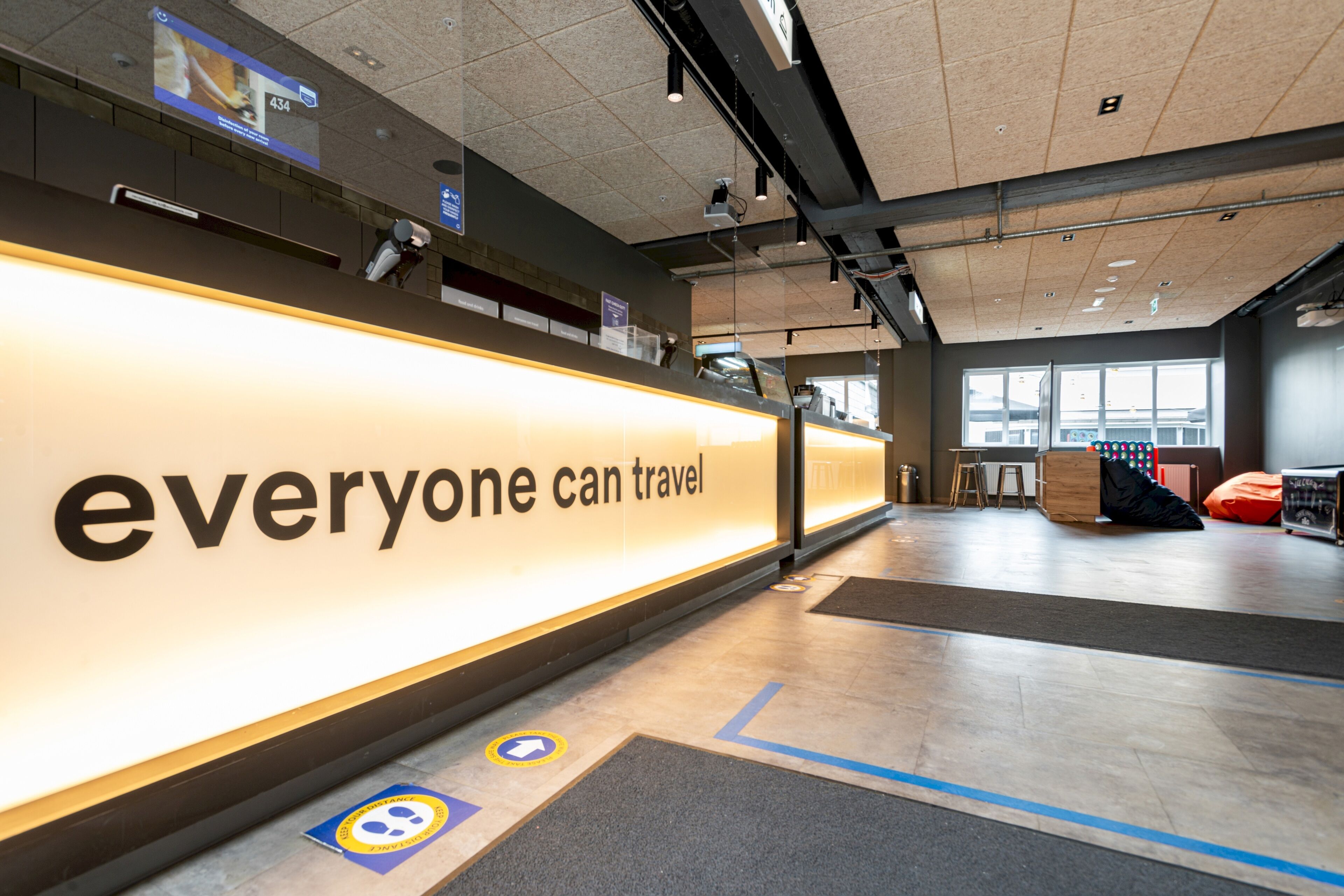 A modern, well-lit reception area with a prominent sign reading "everyone can travel."