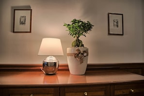 A desk with a lamp and a potted plant.
