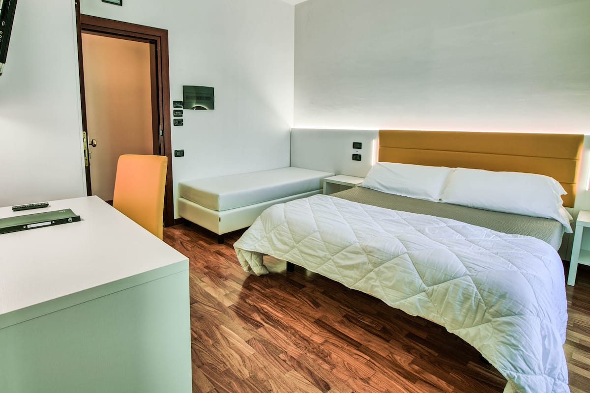 Une pièce comprenant un lit, un bureau et une chaise.