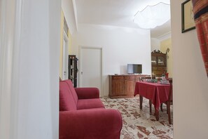 Cozy living space with a sofa, dining table, and TV.