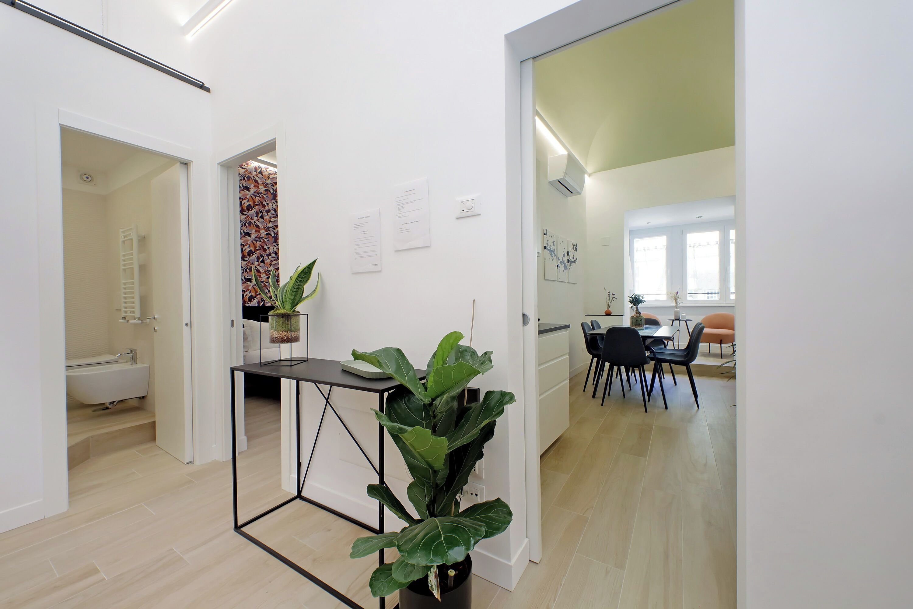 A modern interior with a dining area, a kitchen, and a bathroom.