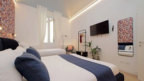 Habitación de hotel moderna con una cama grande, un escritorio, una silla, un televisor y un espejo.
