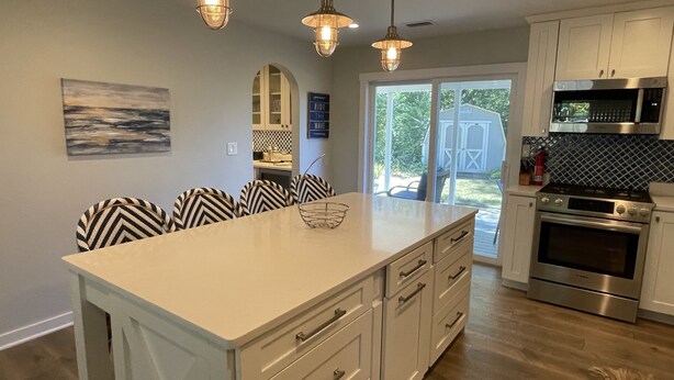 A kitchen with a large island, stainless steel appliances, and a view to the outdoors.