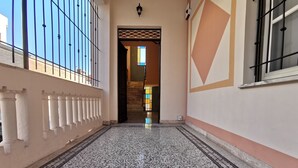 A corridor with a patterned floor, a gate, and a staircase leading to an upper level. - B&B Ad Quintum Torino (Collegno)