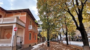 A street lined with trees and buildings, a no entry sign, and a sidewalk covered with fallen leaves. - B&B Ad Quintum Torino (Collegno)