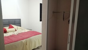 A bedroom with a bed, a bedside table, and a wardrobe. - House in private subdivision (Aguascalientes)