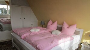 Quarto com cama, penteadeira, espelho e abajur.