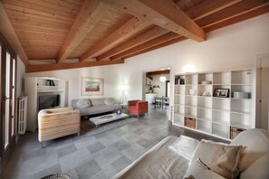 A spacious living area with a high wooden ceiling, a sofa, a striped bench, a bookshelf, and a television. - La Mancina is just 150 meters away from the main beaches of Marina di Ragusa (Marina di Ragusa)