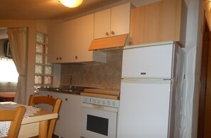 Enjoy meal preparation and dining in this functional kitchen with a stove, sink, and refrigerator.
