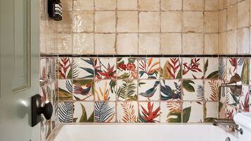 Luxe driepersoonskamer | Badkamer | Een douche, een regendouche, designer toiletartikelen, een haardroger