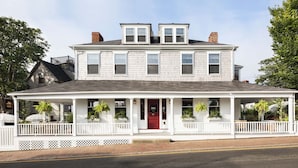 A two-story white building with a red door and a covered porch. - Life House, Nantucket (Nantucket)