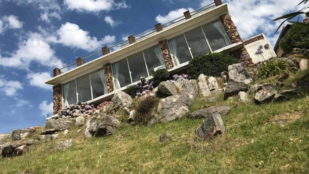 A modern house with a glass facade, stone pillars, and a stone foundation. - Beautiful House Privileged Location Unique View (maldonado)