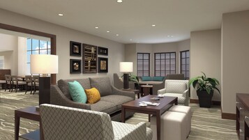 A hotel room with a sofa, armchairs, a dining table, and a large window with blinds.