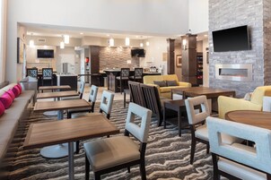 Um hall de hotel moderno com bar, área de estar e lareira.