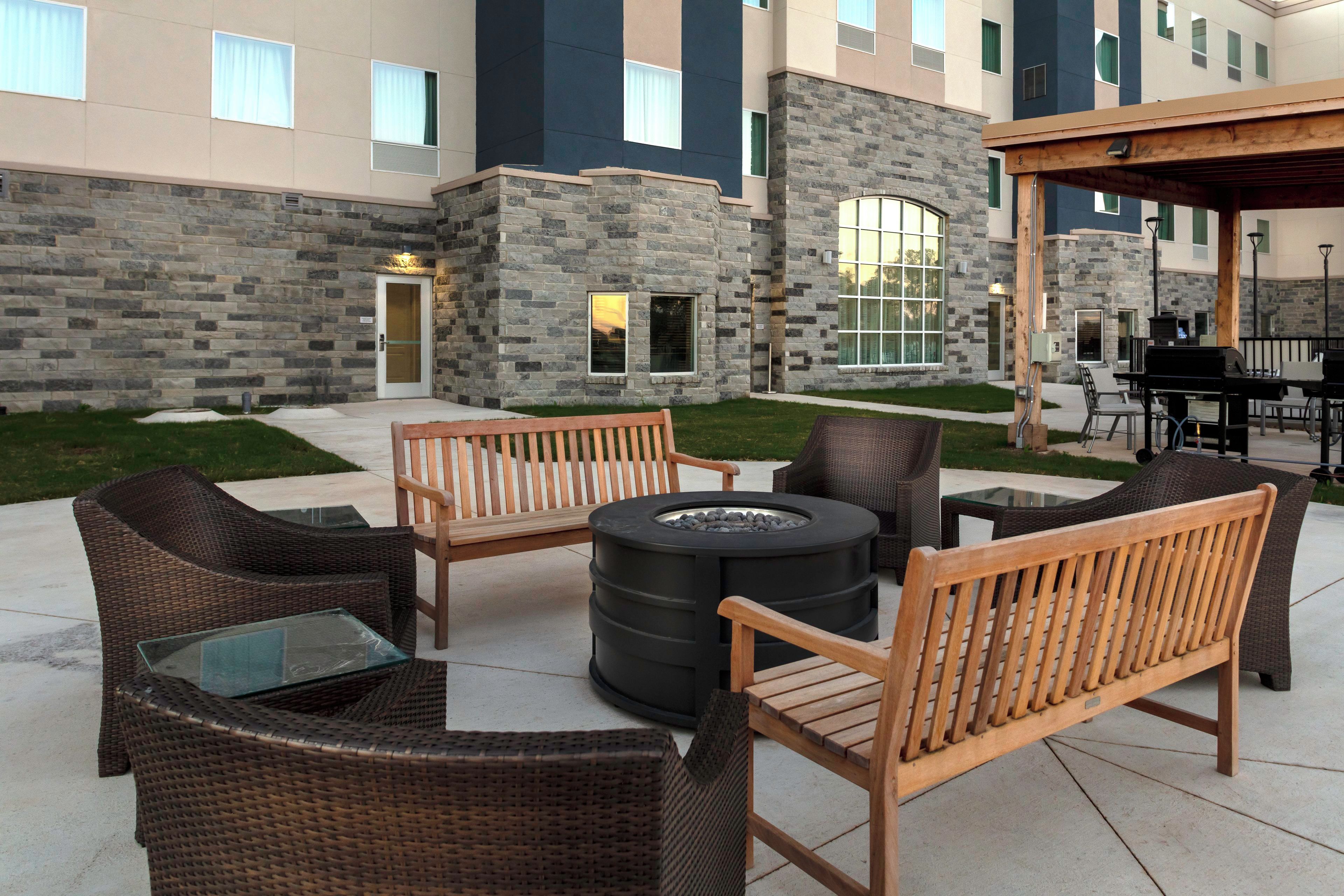 An outdoor seating area with wicker furniture and a fire pit.
