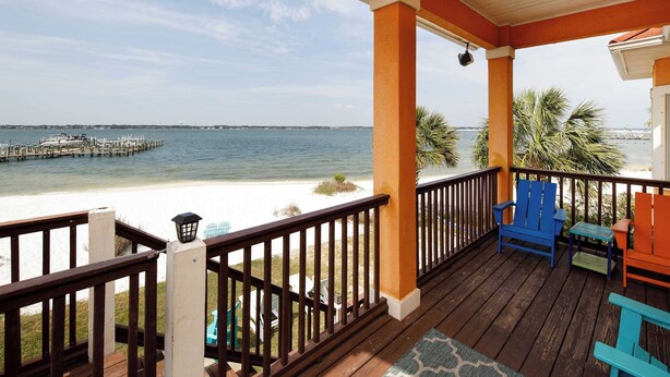A wooden deck with a railing overlooking a beach and the ocean. - Seascape🐚Bayfront Home🌊Boat Slip🐶Dogs OK (Navarre)