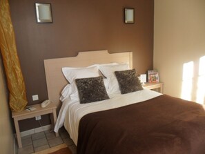 A hotel room with a bed, two bedside tables, a nightstand, a lamp, and a window. - Hotel La Buissonniere (Bannay)
