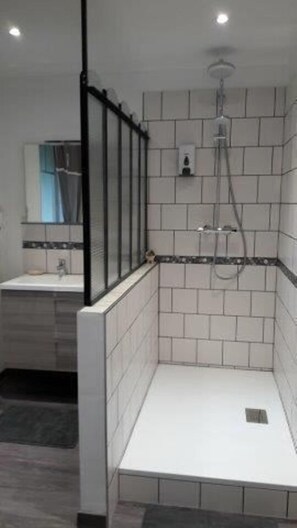 Superior tweepersoonskamer | Badkamer | Een douche, een haardroger, handdoeken, zeep