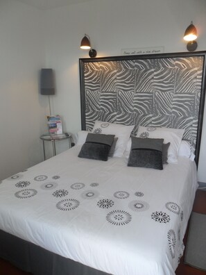 A neatly made bed with a zebra-patterned headboard, two bedside lamps, and a sign above the headboard that reads "Sleep well with a nice dream." - Hotel La Buissonniere (Bannay)