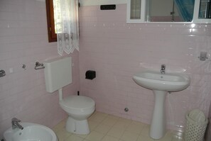 A bathroom with a toilet, bidet, sink, and a trash bin. - Villa Ca' Del Portegheto 1 - Lignano Sabbiadoro (Lignano Sabbiadoro)