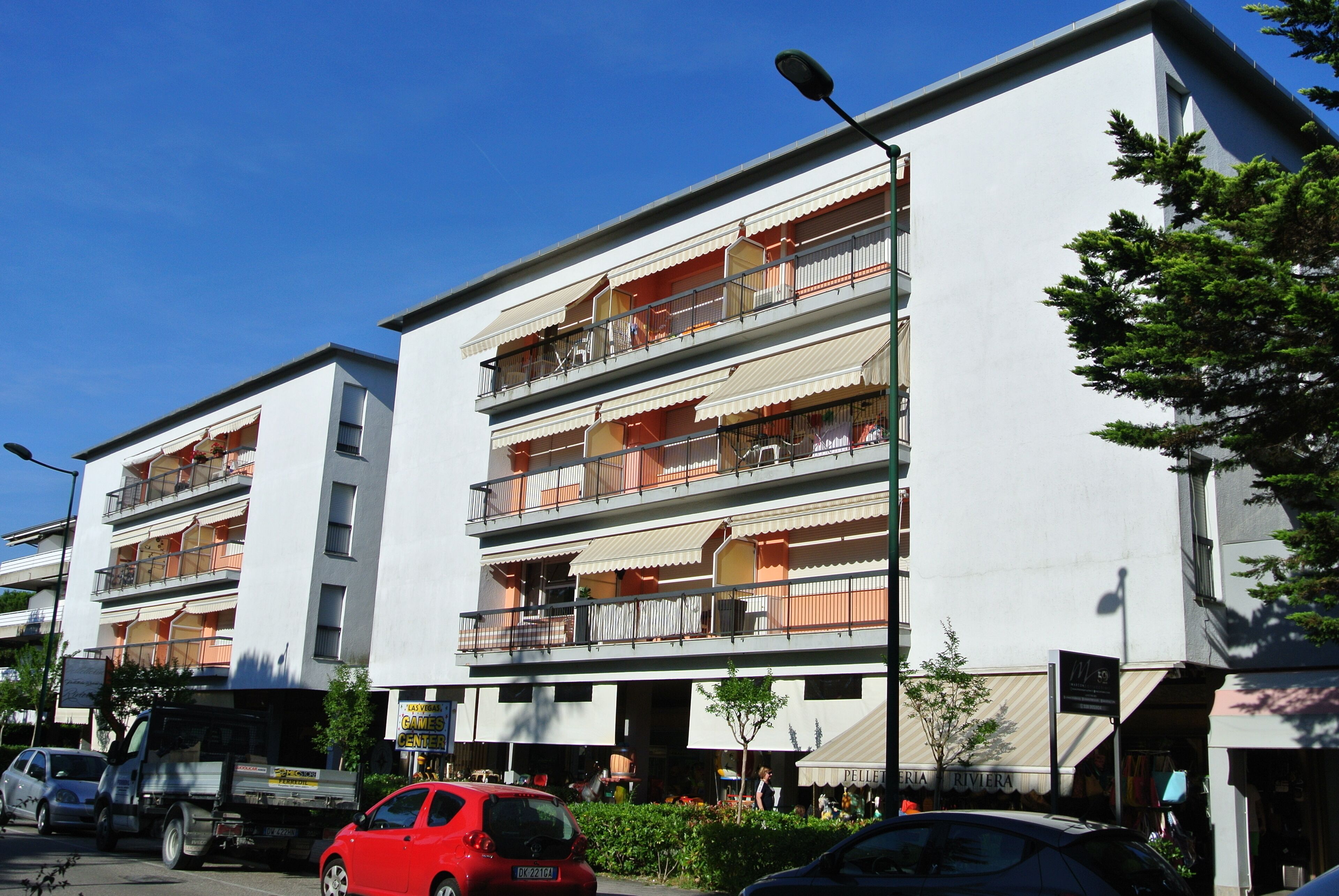 Un immeuble résidentiel à plusieurs étages, doté de balcons, donnant sur une rue.