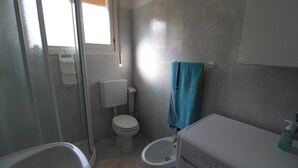 Un baño con inodoro, bidé y bañera.