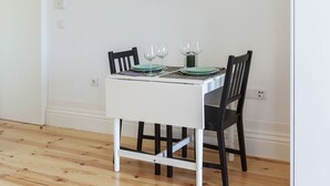 Una mesa de comedor con cuatro sillas, un mantel individual y tres copas de vino.