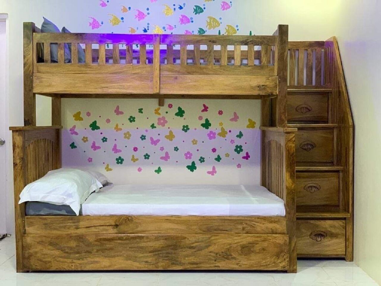 Een stapelbed met houten frame, een bed beneden en een ladder.