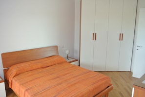 Une chambre à coucher comprenant un lit, une table de chevet, une armoire et une commode.