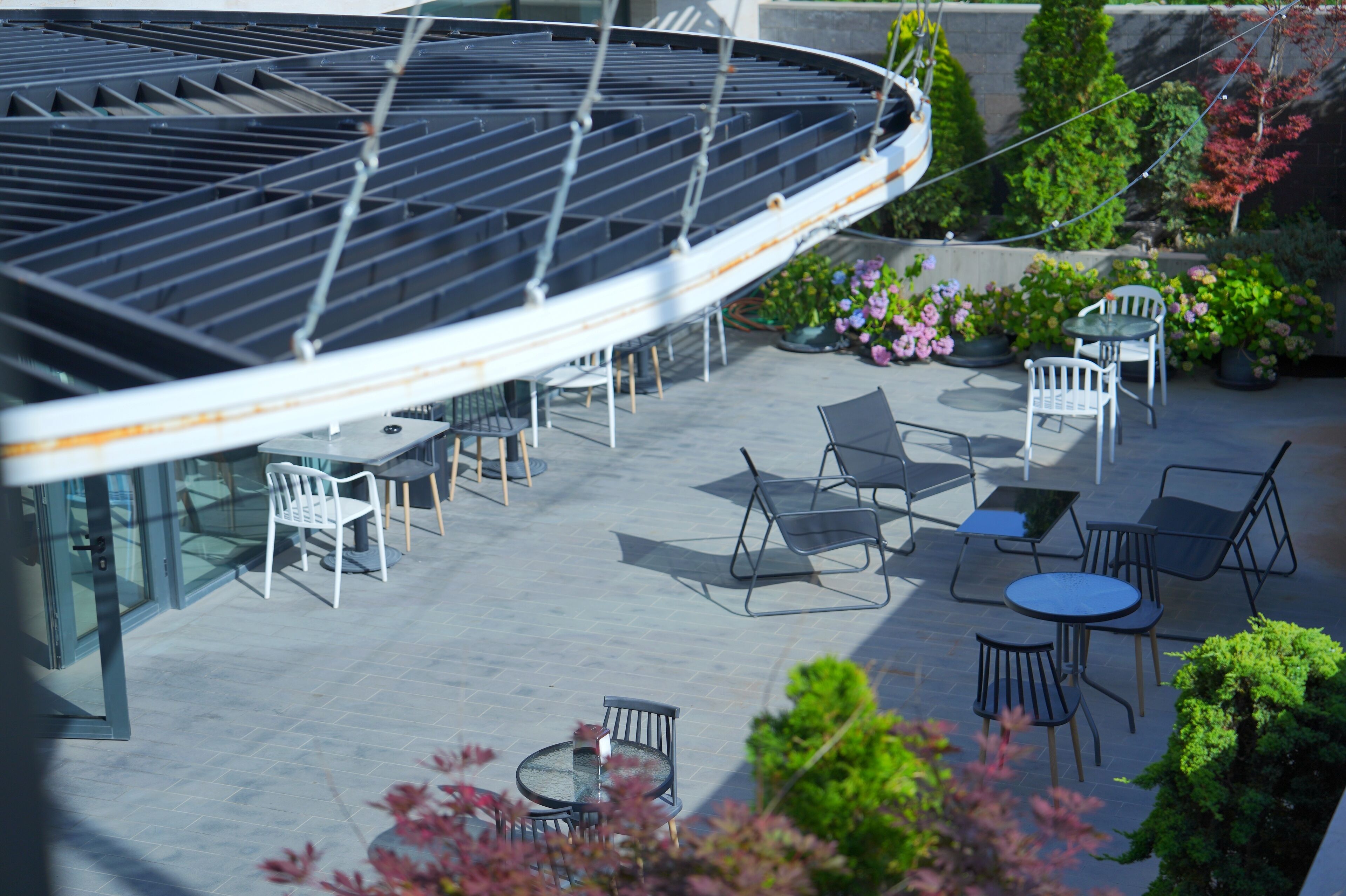 Um terraço no telhado com área de estar ao ar livre e um compartimento de vidro.