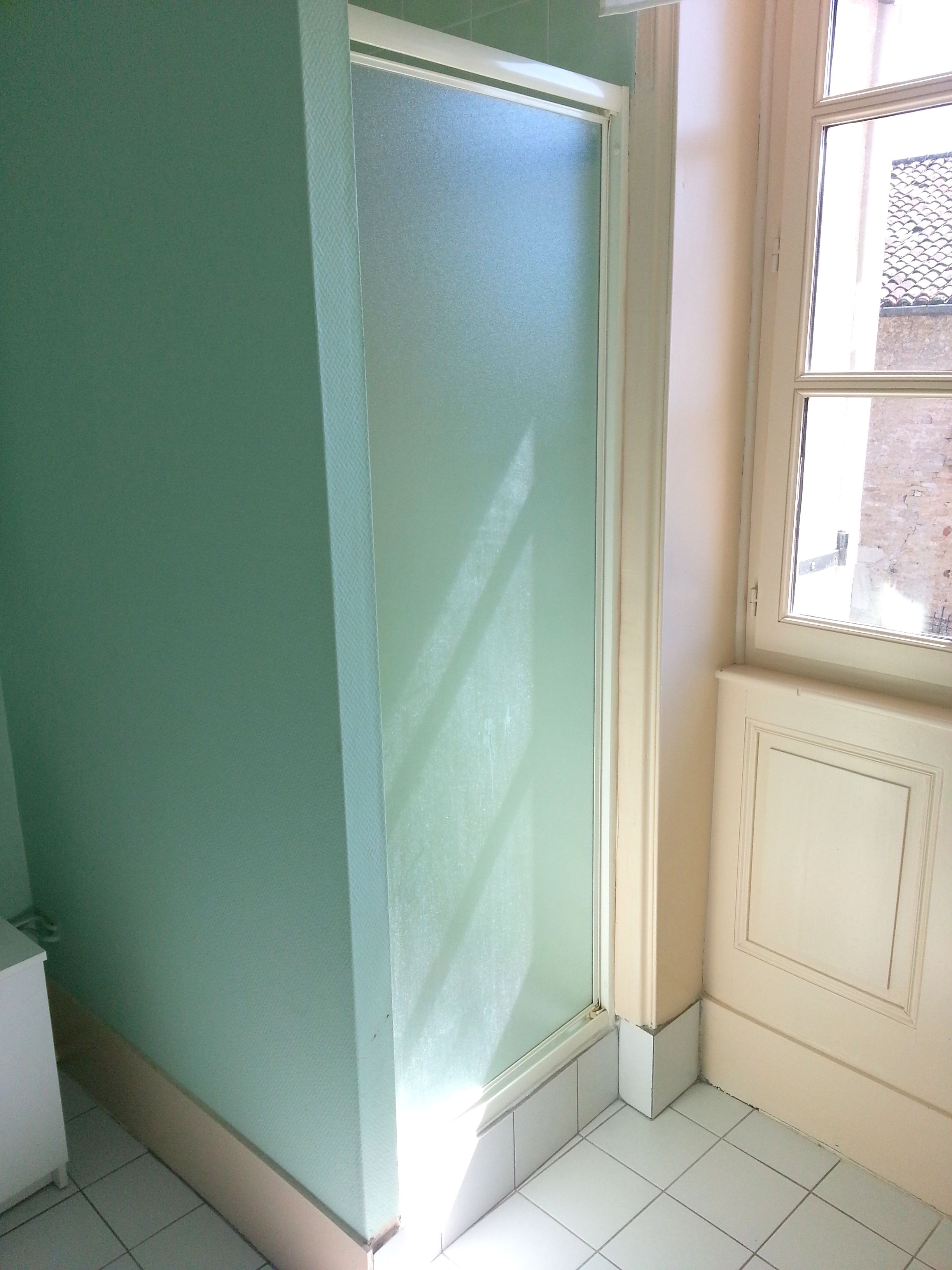A room with a green wall, a white door, and a window.