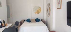 A hotel room with a bed, a table with bottles, and a chair. - TERRACES OF THE DUKE II (Costa Adeje)
