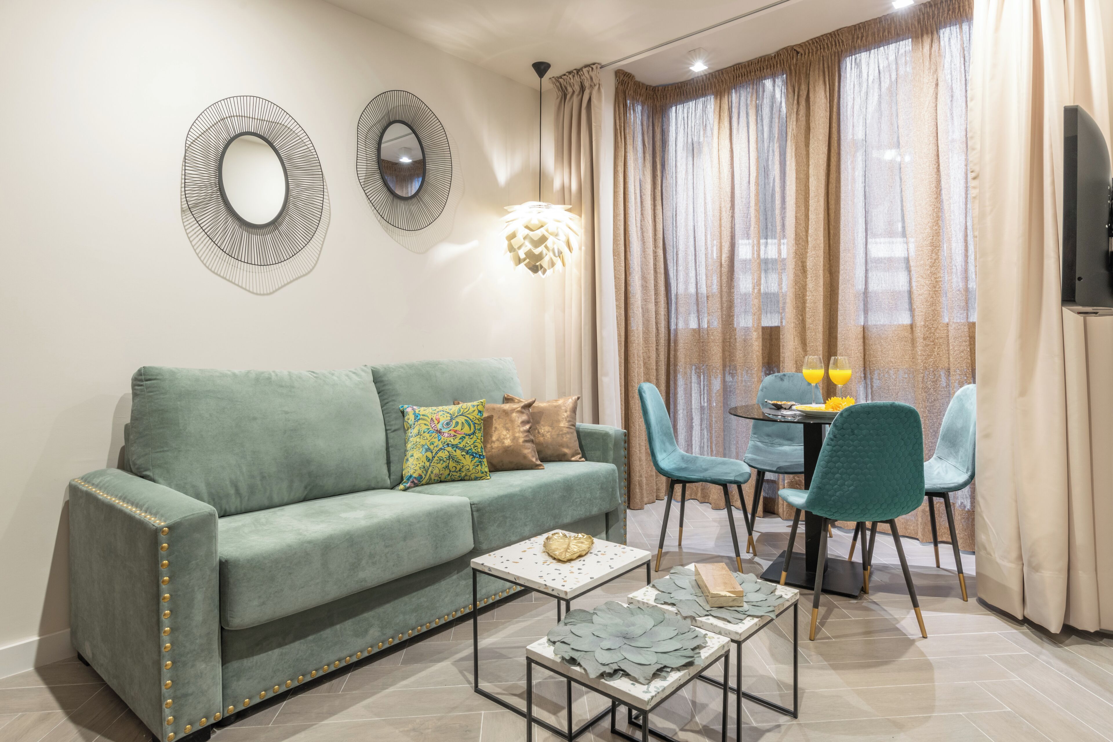 Una sala de estar con un sofá, dos sillones, una mesita y un televisor.