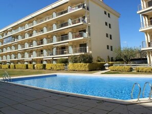 A multi-story hotel with balconies, a swimming pool, and well-maintained landscaping.