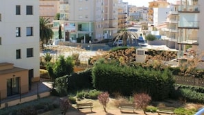 A residential area with multi-story buildings, a paved courtyard with benches, and a small pool.