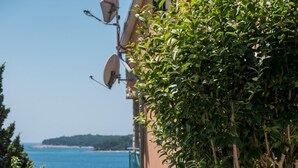 A coastal building with a balcony overlooking a body of water.