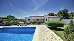 Una propiedad residencial con piscina, patio y jardín.