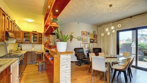 Una cocina moderna con armarios de madera, un comedor con mesa y sillas, y un ventanal con vistas al exterior.