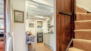 A kitchen with wooden flooring, a built-in oven, and a tiled backsplash. - Vine Cottage - UKC4237 (Great Snoring, near Fakenham)